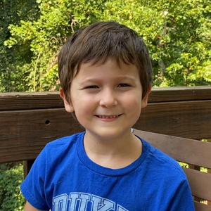little boy in blue shirt smiling