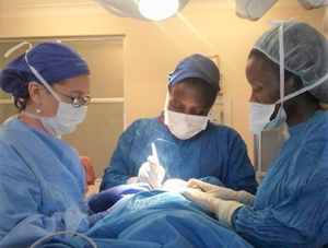 Women performing surgery on a baby